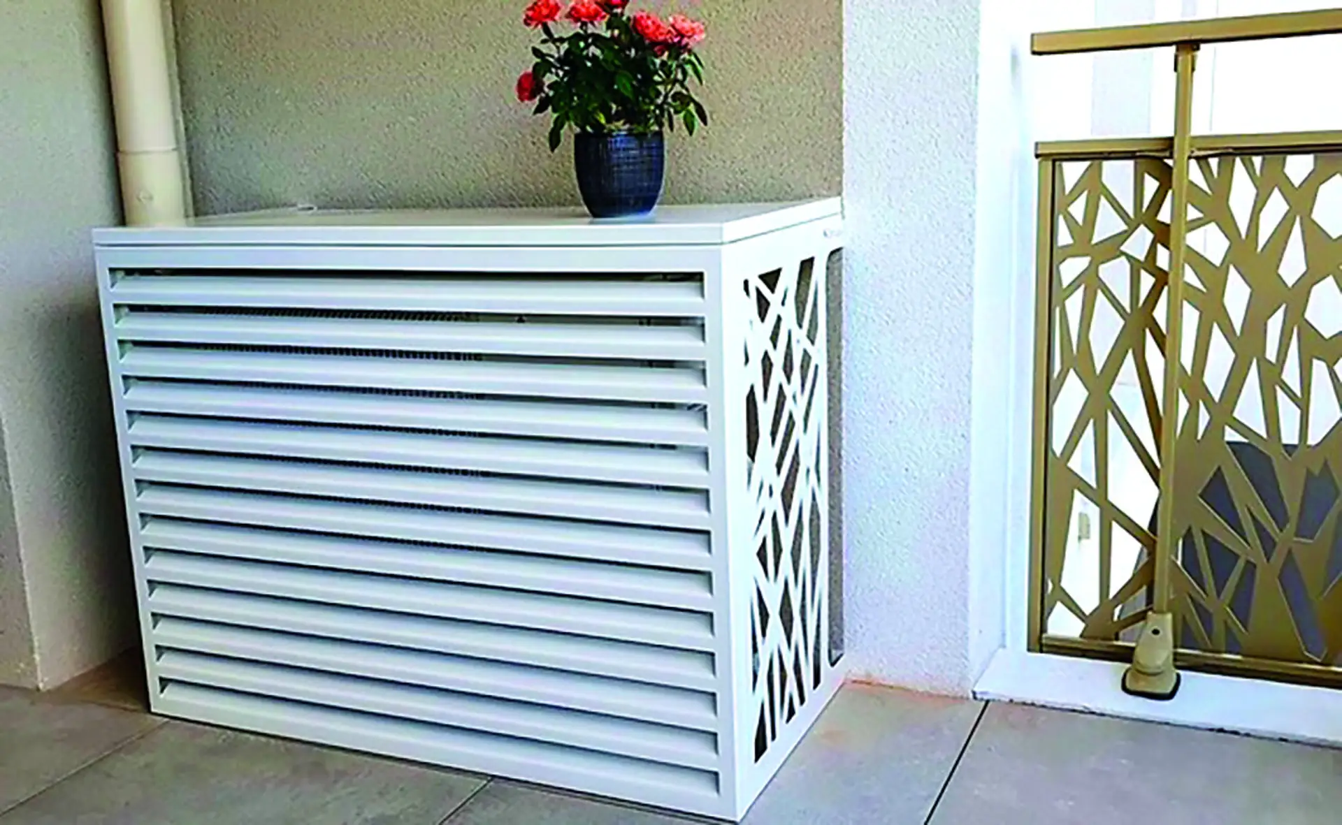 Cache-clim Devaux blanc sur un balcon, à côté d'un garde-corps décoratif