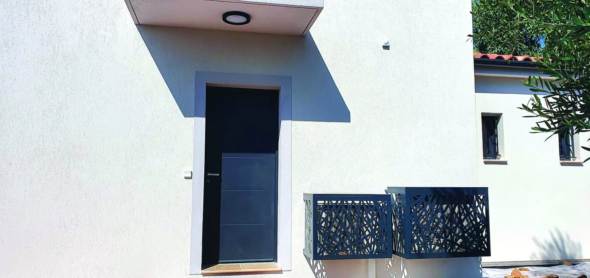 Deux caches-clim Devaux gris anthracite sur une villa moderne